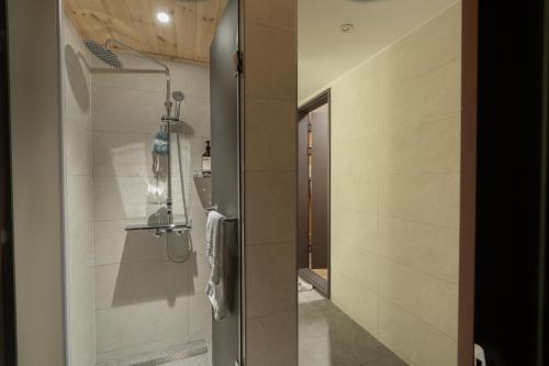 a bathroom with a shower with a glass door at Boro Hanok Hostel in Myeongdong in Seoul