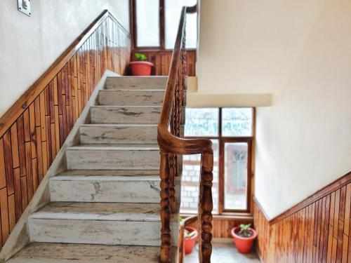 a staircase in a home with a wooden stair case at Tripti Villas in Manāli