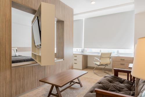 a living room with a couch and a tv on a wall at Boutique Apartament Carso Alameda-1002 in Mexico City
