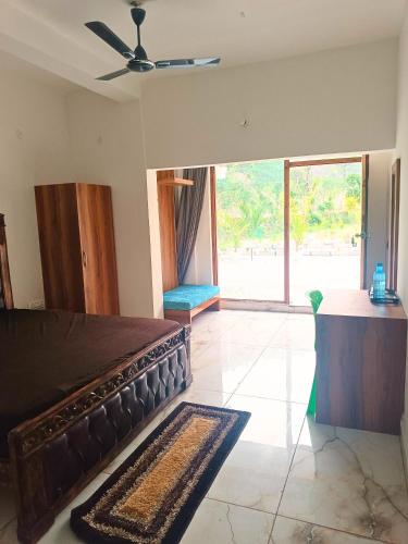 a bedroom with a large bed and a large window at Lamyali Farm in Rishīkesh
