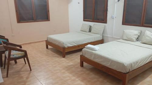 a room with two twin beds and a chair at Villa Chic in Chicxulub