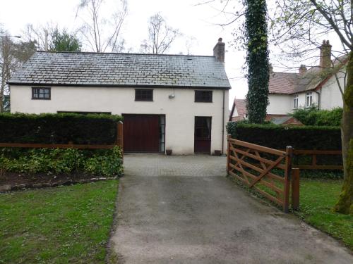 a white house with a garage and a fence at Glen-Yr-Afon House Hotel in Usk