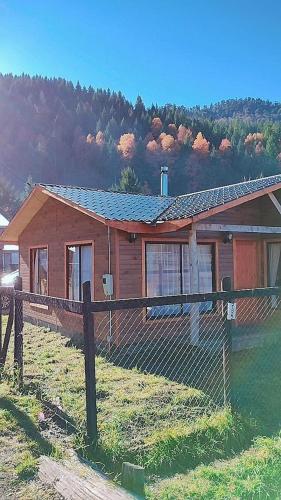 a wooden house with a fence in front of it at Prana sur neltume in Neltume