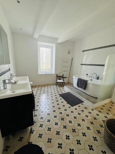 une salle de bain avec une baignoire et un lavabo dans l'établissement Le petit château de vacances, à Ginestas