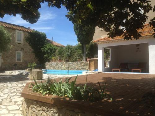 a house with a swimming pool in a yard at Le petit château de vacances in Ginestas