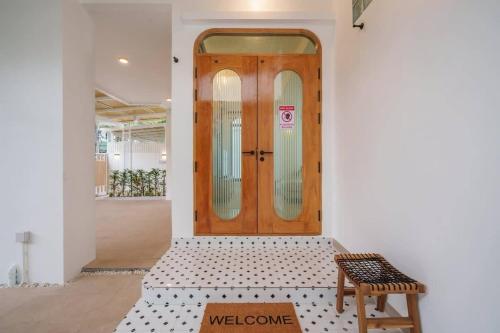 a wooden door with a bench in front of it at Ayas Retreat - Muji Ekkamai Pool Villa with 4 bedrooms in Khlong Toei