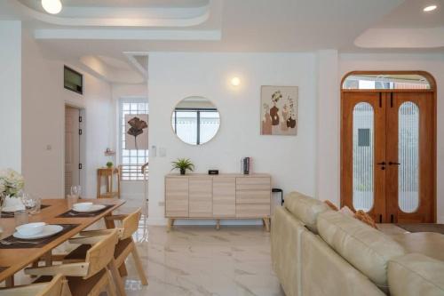 a living room with a couch and a table at Ayas Retreat - Muji Ekkamai Pool Villa with 4 bedrooms in Khlong Toei