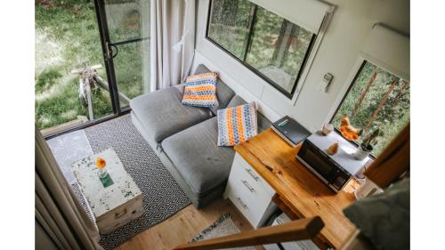 a small living room with a couch and a desk at Bedervale Tiny by Tiny Away in Braidwood