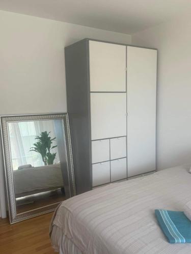 une chambre avec un grand lit blanc et un miroir dans l'établissement Croisette-Plages Centre, à La Celle-sous-Gouzon