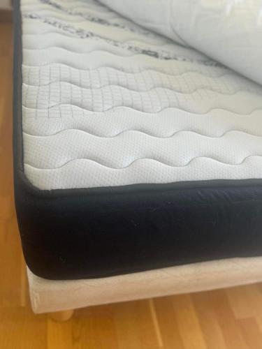 - un lit avec un matelas noir et blanc dans l'établissement Croisette-Plages Centre, à La Celle-sous-Gouzon