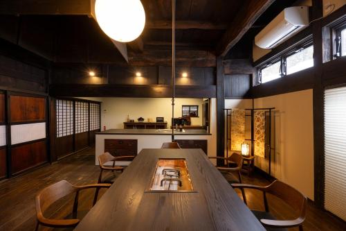 a dining room with a large wooden table and chairs at 雪の家 古澤邸 in Tokamachi