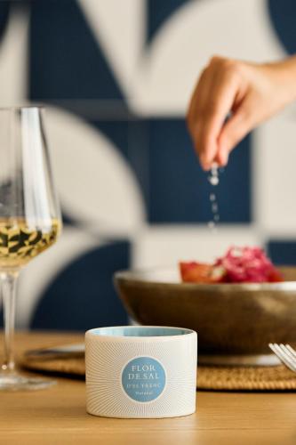 a person is preparing food on a table with a glass of wine at Iberostar Selection Es Trenc -New Opening- in Colonia Sant Jordi