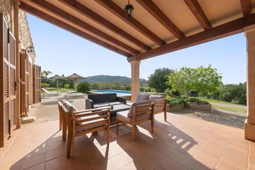 an outdoor patio with two chairs and a table at Cas Batlet in S'Horta