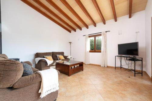 a living room with a couch and a tv at Cas Batlet in S'Horta