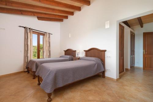 two beds in a room with white walls at Cas Batlet in S'Horta