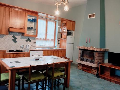 a kitchen with a wooden table and a fireplace at Casale del sole in Palestrina