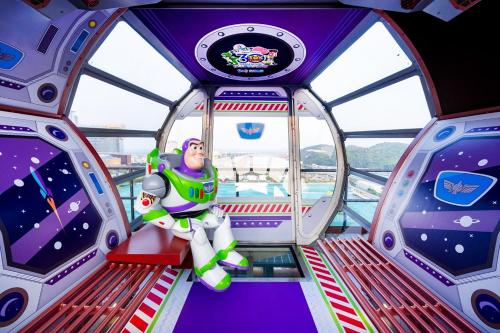 a toy man is sitting on a ride in a spaceship at Studio City - Epic Tower in Macau