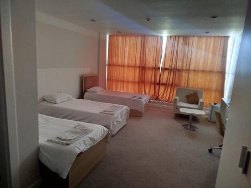 a hotel room with two beds and a window at Arena Hotel Shirvan in Əli Bayramlı Stansiyası
