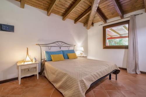 a bedroom with a bed with blue and yellow pillows at Villa Toni in Stintino