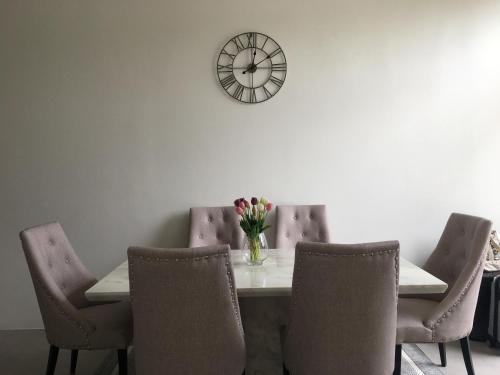 a table with chairs and a clock on the wall at The Midst by The M - Nakhon Nayok TMD4 in Ban Som Phung Haeng (1)