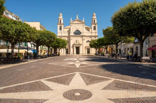 a street in front of a building with a clock tower at Horizon Loft - Free Parking - AC - Smart TV in Pietra Ligure