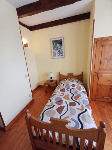 une chambre avec un lit et un parquet dans l'établissement Gîte LES LILAS de RECOULES, à Le Massegros
