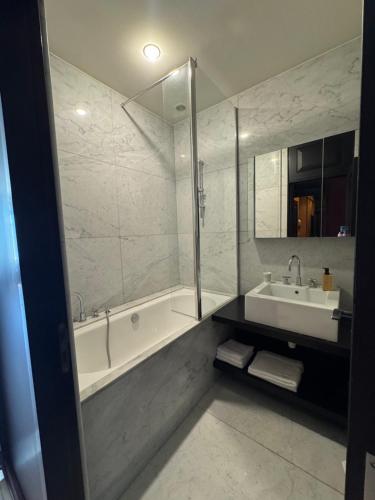 une salle de bain avec une baignoire, un lavabo et un miroir dans l'établissement Tour de la chaine, vieux port, Grand Appartement, à La Rochelle