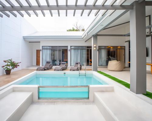 a swimming pool in a house with a patio at Villa Kalachuchi Bohol in Panglao