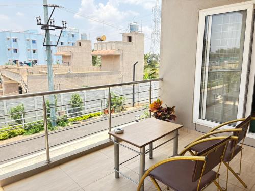 a balcony with a table and chairs and a window at Sai Grand Villa Hotel Near Bangalore Airport in Bengaluru
