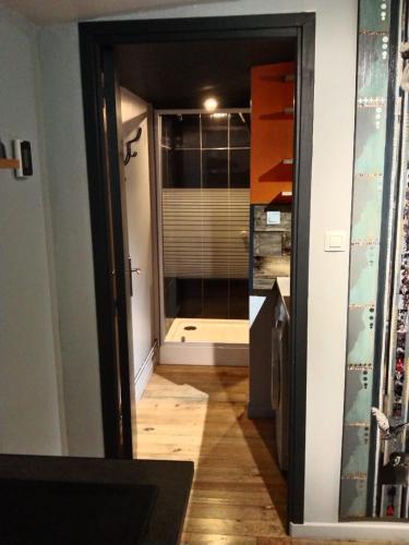 - un couloir avec une porte en verre menant à une salle de bains dans l'établissement La Villa Saint Ghislain, à Thivencelle