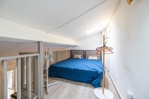 - une chambre mansardée avec un lit bleu dans l'établissement Le Repaire du Sud - 8min de la Plage, à Saint-Cyprien