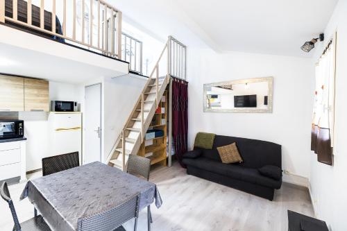 un petit salon avec une table et un canapé dans l'établissement Le Repaire du Sud - 8min de la Plage, à Saint-Cyprien