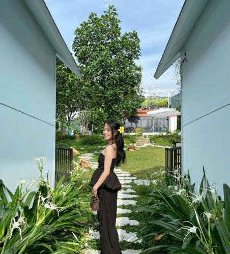 a woman in a black dress standing on a walkway at Tony Villa Homestay Ba Vì in Ba Vì