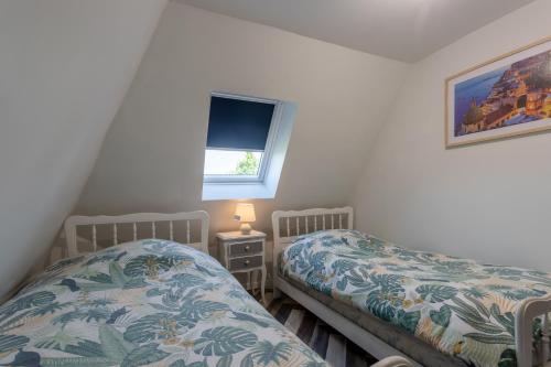 ein Schlafzimmer mit zwei Einzelbetten und einem Fenster in der Unterkunft Gîte les Charmilles in Mont