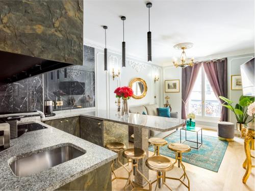 - une cuisine avec un évier et des tabourets de bar dans l'établissement Merveil - Luxury Suite -Champs Elysees-Ponthieu II, à Paris