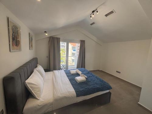 a bedroom with a bed with blue sheets and a window at Summer Stories Kallithea in Kallithea Halkidikis