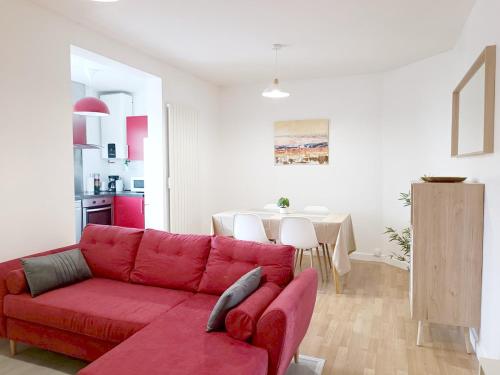 un salon avec un canapé rouge et une table dans l'établissement Le Pontchâtelain T3 Hypercentre, à Pontchâteau