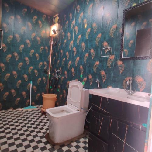 a bathroom with a toilet and a sink at Kedar Avnita Resort in Gupta Kāshi