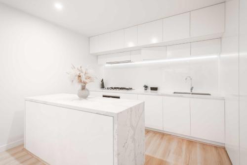 a white kitchen with a counter and a sink at Doncaster Lux 3b2b Apt Balconyparking in Doncaster
