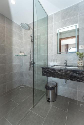 a bathroom with a glass shower and a sink at Bamboo Riverside Boutique Hotel in Ben Tre