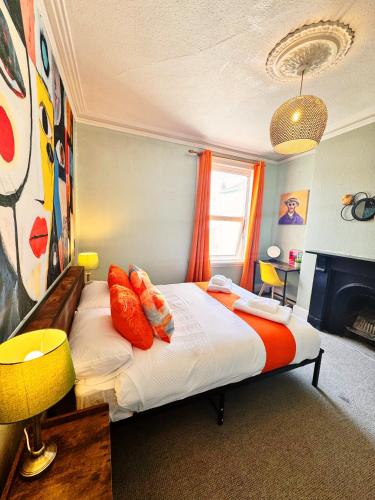 a bedroom with a bed with orange pillows on it at Best Offer Spacious and Chic 2 Bed Apartment in Plymouth