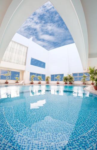 a swimming pool in a building with an archway at AURORA Hotel Plaza in Bien Hoa