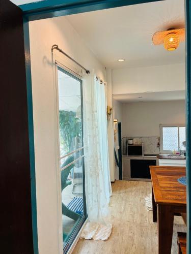 a living room with a sliding glass door and a kitchen at Dream Villa Beachfront Sunset in Ban Bang Po