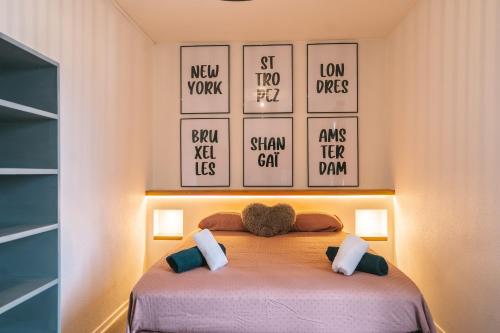 une chambre avec un lit avec quatre tableaux au mur dans l'établissement Magnifique T3-terrasse-parking-Centre ville-AD, à Carcassonne