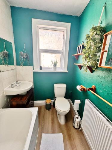 a bathroom with a toilet and a tub and a sink at Best Offer Spacious and Chic 2 Bed Apartment in Plymouth