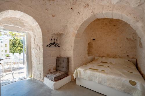 a bedroom with a bed and a window at Villa Stellina and Trullo Cecé in Ostuni