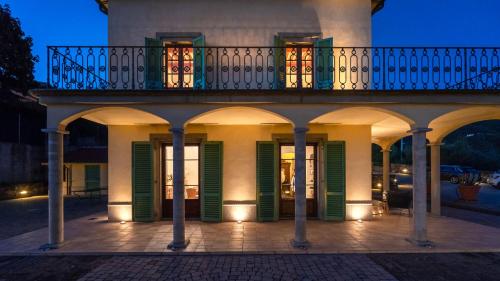 a building with green shutters and a balcony at Panoramic villa between Lucca and Florence in Pescia