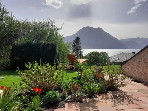 a garden with a view of the water and mountains at Gallery - Terrasse mit Seeblick und Garten in Altmünster