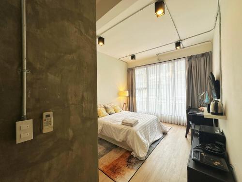 a bedroom with a bed and a desk in a room at 260m walk to BTS Prakanong in Bangkok