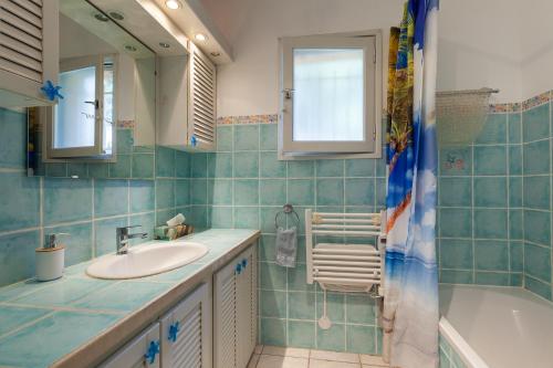une salle de bain avec un lavabo, une baignoire et un miroir dans l'établissement Tres Beau T2 - 50 M - Vue Mer, à Carry-le-Rouet